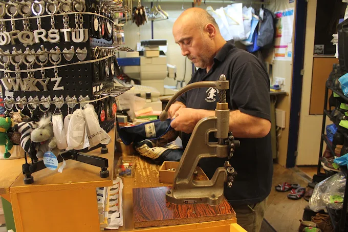 Onze schoenmaker aan het werk met de drukpers